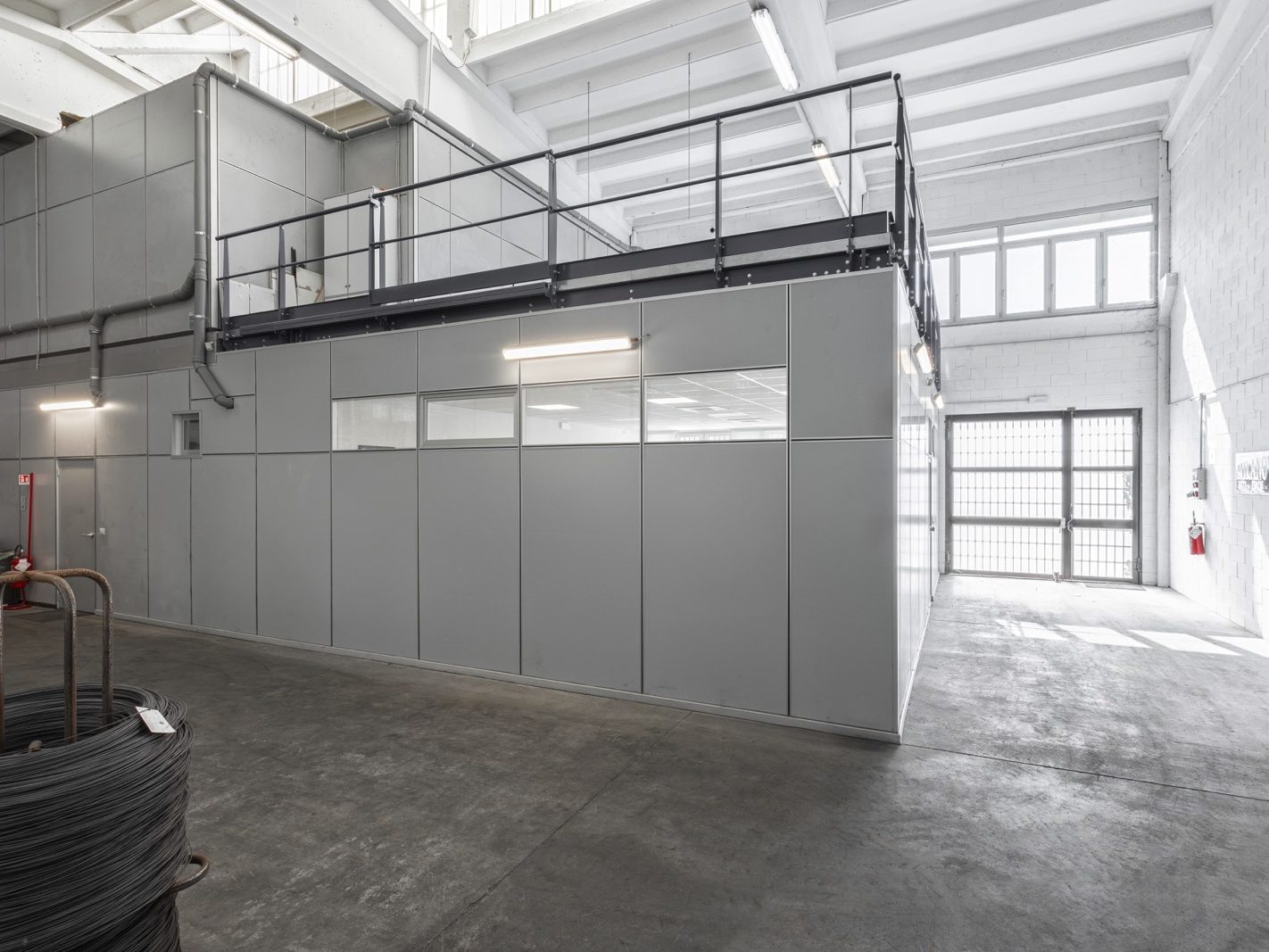 Vista Esterna dell'Ampliamento. In foto l'ampliamento della palazzina uffici visto dall'esterno. Le pareti divisorie Maisistem Omega sono visibili, con una combinazione di pannelli opachi e finestre che garantiscono luminosità e privacy.