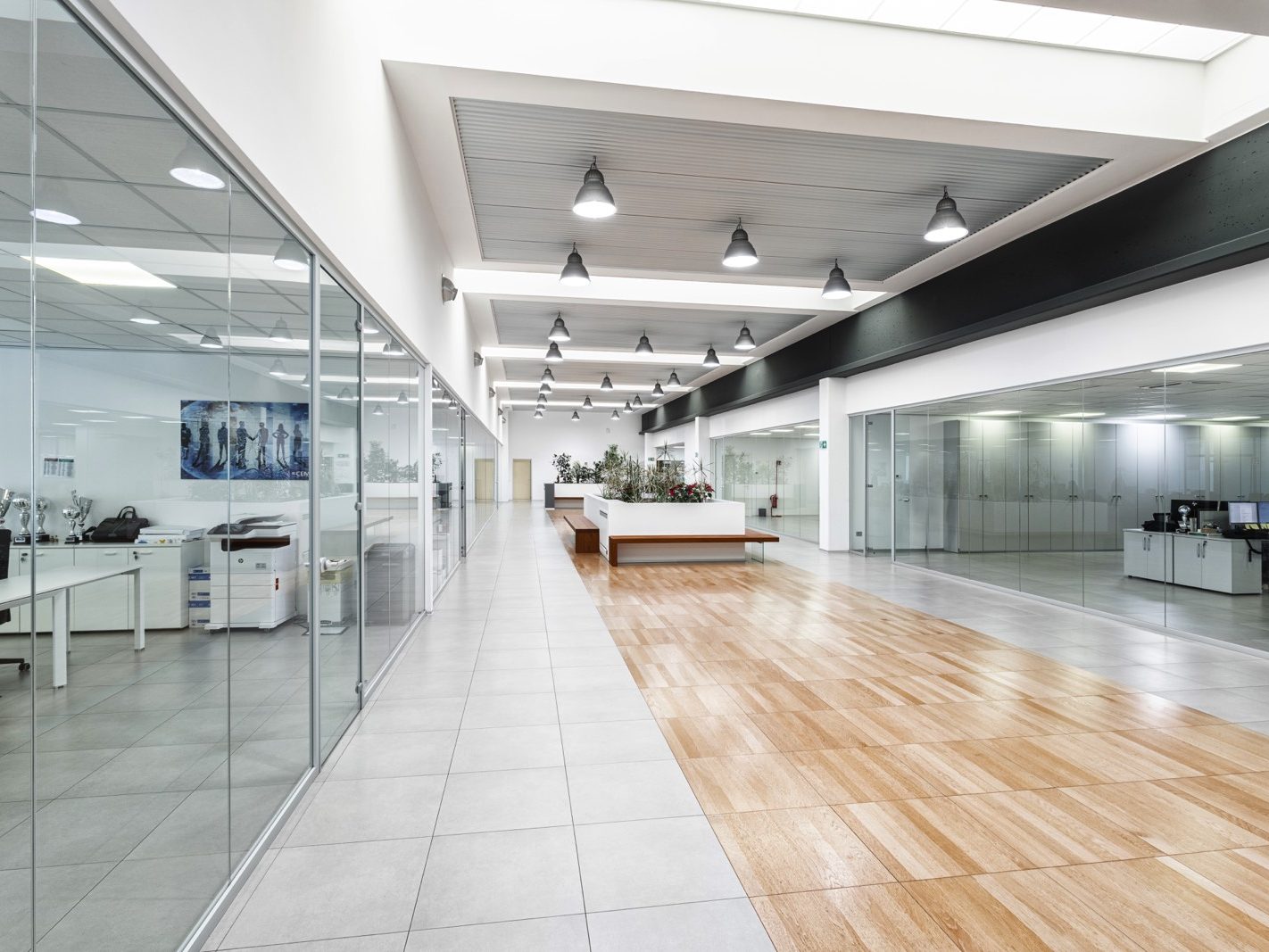 Area di Lavoro Comune. Un'ampia area di lavoro comune, caratterizzata da spazi aperti e luminosi. Le pareti di vetro e il pavimento sopraelevato migliorano l'efficienza e la funzionalità dello spazio, creando un ambiente di lavoro moderno e accogliente.