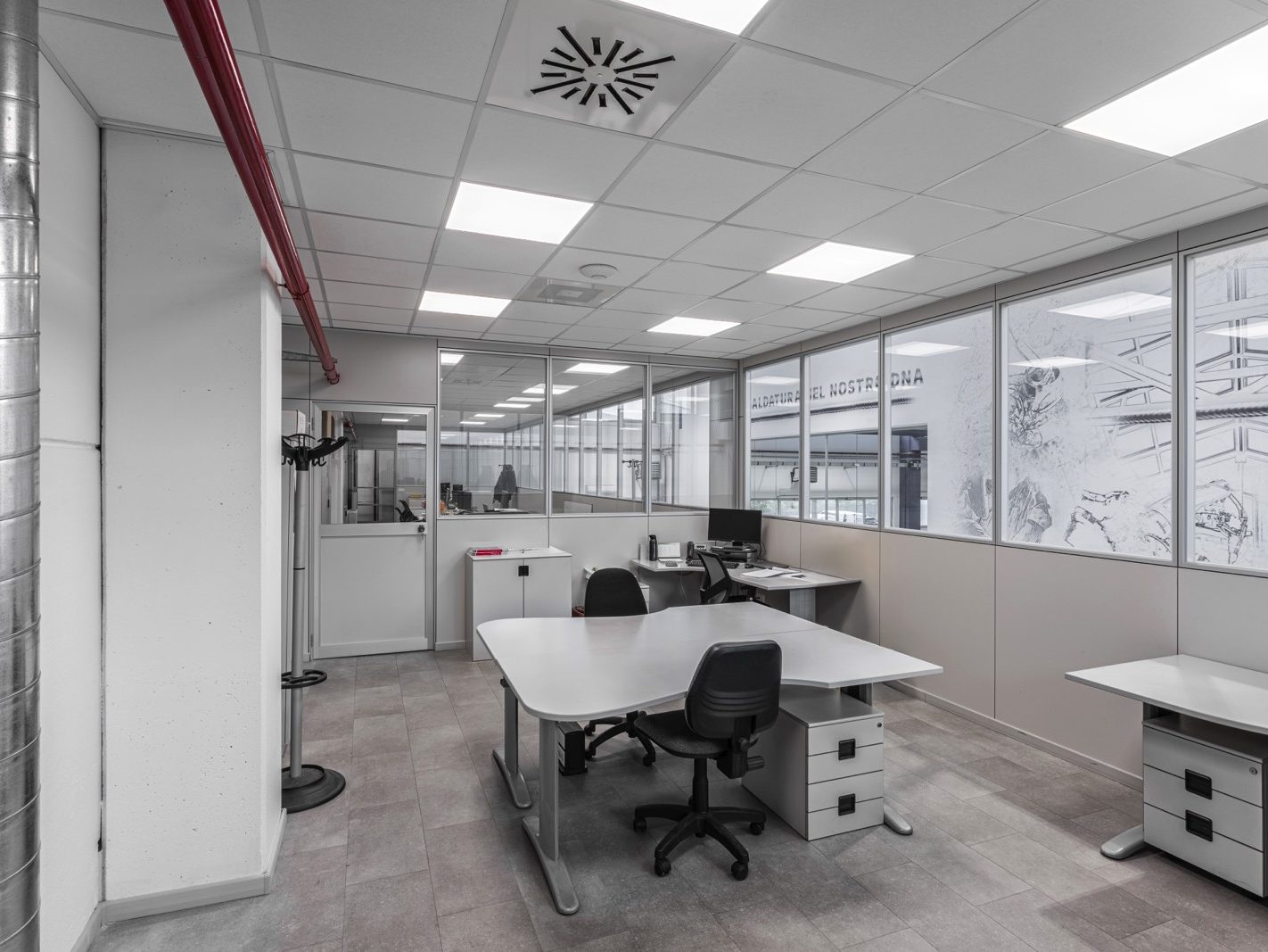 Le pareti divisorie in vetro e i pannelli opachi garantiscono sia la trasparenza che la privacy necessarie.