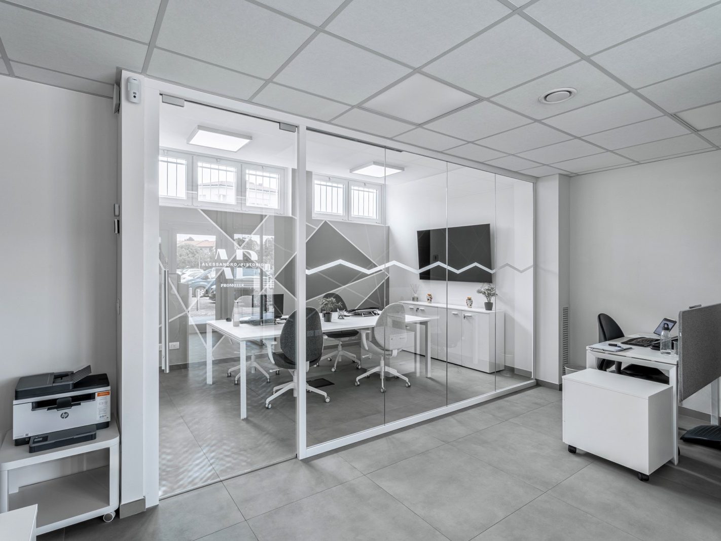 Un'altra vista della sala riunioni, che mette in evidenza la continuità delle pareti vetrate e l'uso di mobili moderni. Il design delle pareti in vetro è funzionale, garantendo sia privacy che trasparenza.