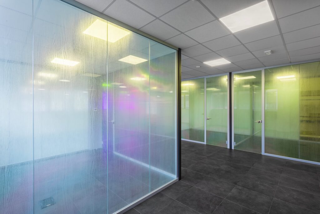 Realizzazione di un'area direzionale moderna e luminosa per COLORI PROJECT, con pareti vetrate su misura