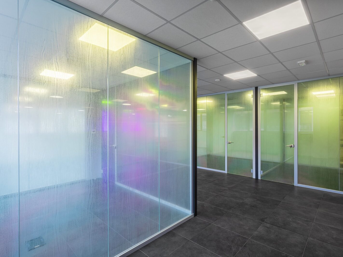 Realizzazione di un'area direzionale moderna e luminosa per COLORI PROJECT, con pareti vetrate su misura