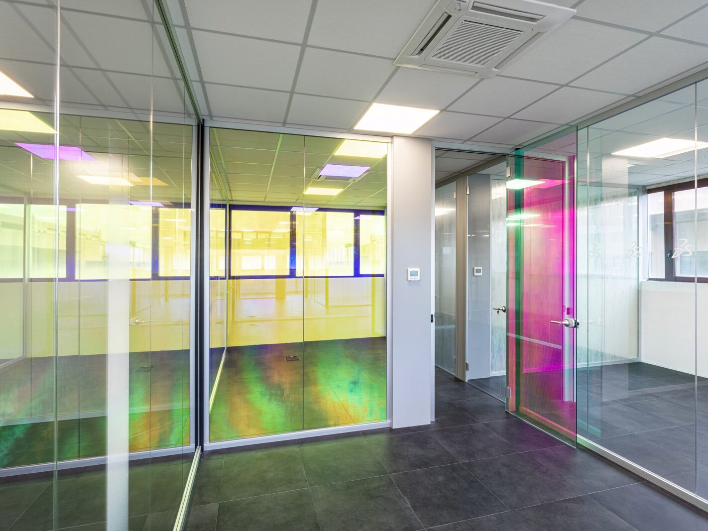 Realizzazione di un'area direzionale moderna e luminosa per COLORI PROJECT, con pareti vetrate su misura