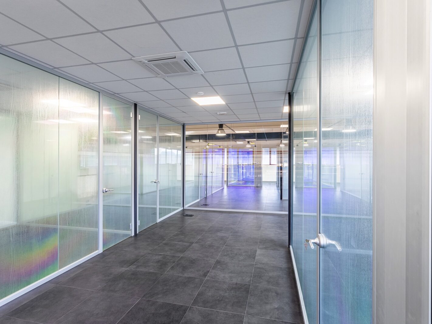 Realizzazione di un'area direzionale moderna e luminosa per COLORI PROJECT, con pareti vetrate su misura